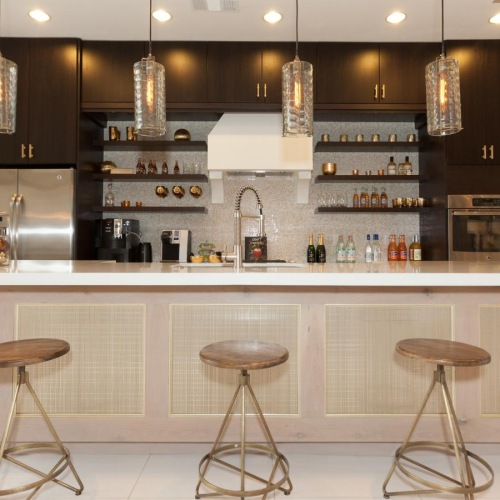 a kitchen with stools and a bar